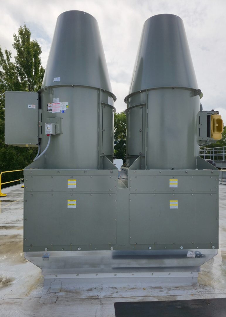 Two new high-plume laboratory exhaust fans standing on their roof curbs against the sky