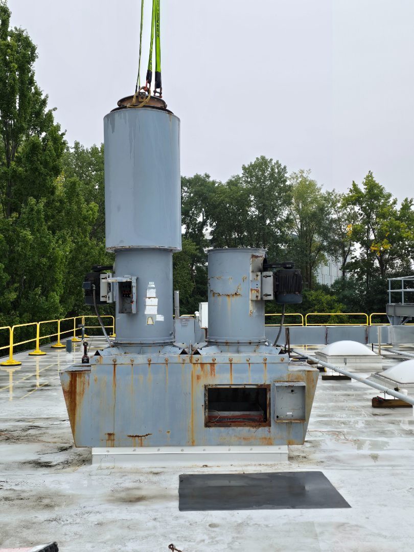 A new exhaust stack being set down onto its roof curb